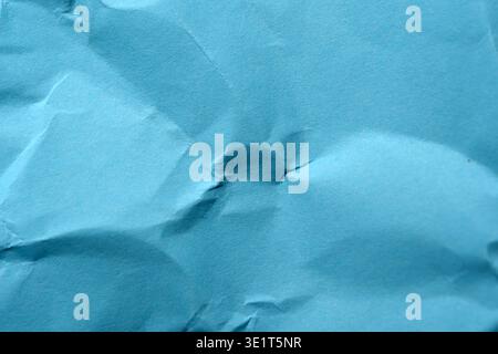 Textured blue paper shows elegant creases under soft light, creating depth. Stock Photo