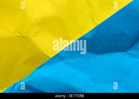 Two vibrant sheets, one yellow and one blue, blend visually with rich textures. Stock Photo