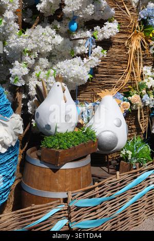 Decorative Easter egg display with white eggs and flowers in a rustic wooden setting. Stock Photo