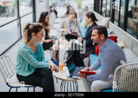 Business collaboration between colleagues discussing ideas over coffee in a modern office lounge Stock Photo