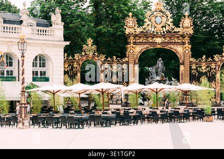 Ornate gilded gates and outdoor café terrace at Place Stanislas, Nancy, France Stock Photo