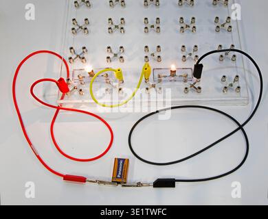 Educational kit for experiments with electrical circuits. A transparent board with terminals for connecting components. The light bulbs are connected Stock Photo