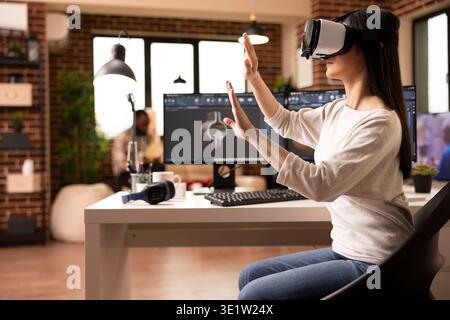 Young woman with vr headset working on clamp model in CAD software at home studio. Freelance female engineer exploring virtual reality environment for accurate 3D product prototyping and inspection. Stock Photo