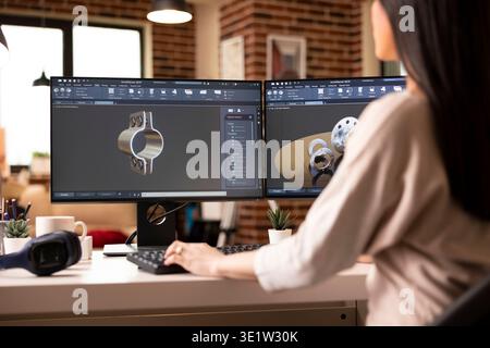 Creative female engineer working remotely in home studio, designing mechanical gear prototypes using CAD and visualization software. Industrial style setup with stylish decor and digital tools. Stock Photo