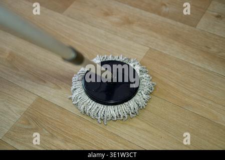 Close-up of a professional minimalist microfiber mop head for floor cleaning. The mop is placed on a textured grey stone or concrete surface with soft organic shadows. Concept of house cleaning, hygiene, and domestic chores. Microfiber Mop on Grey Concrete Background. High quality photo Stock Photo