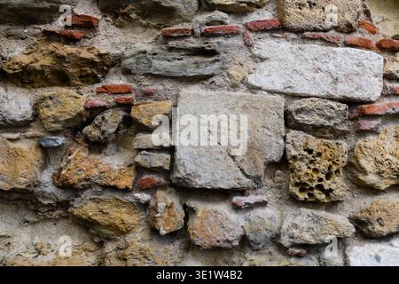 Textured, abstract pattern formed by old, weathered brick and stone masonry on a building in the historic Alfama neighorhood of Lisbon, Portugal. Stock Photo