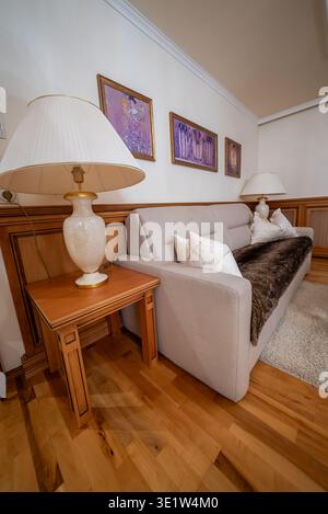 Hotel lounge corner with sofa, faux fur throw, and ceramic lamps Stock Photo