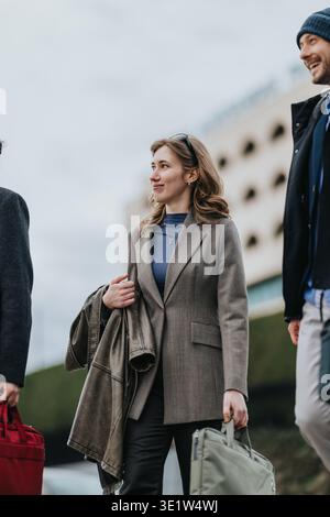 Business associates walking together in the city carrying bags and outerwear on a commute Stock Photo