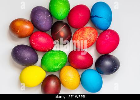 Easter eggs painted in different colors, custom patterns on a white background, top view Stock Photo