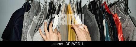 Header of Young Adult Woman Selecting Clothes from Wardrobe Hanging on Rack Stock Photo
