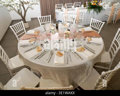 Elegant wedding reception table set for guests with refined tableware, floral centerpieces, and decorative elements. Stylish banquet setup in a recept Stock Photo