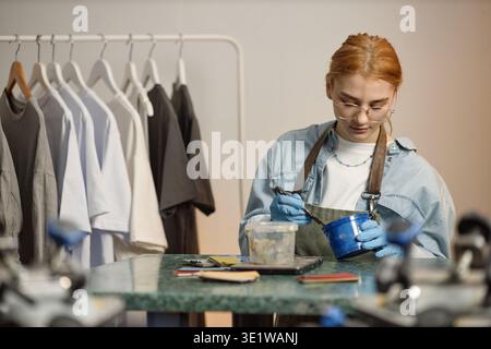 Young Adult Woman Mixing Paint While Working in Creative Studio Stock Photo