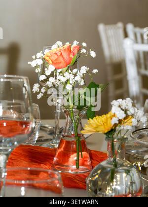 Elegant floral centerpiece with pink rose and white flowers in a glass vase, ideal for weddings, receptions, and refined dining settings. Stock Photo