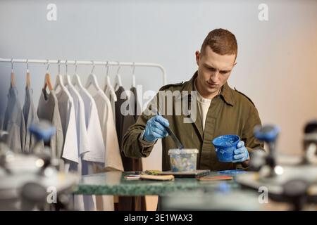 Young Adult Man Mixing Paint While Working in Creative Studio Stock Photo