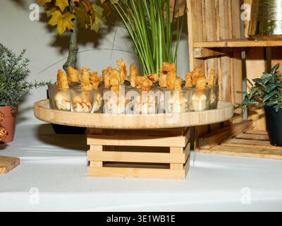 Shrimp appetizers served in small cups on a rustic wooden stand, perfect for catering events, cocktail parties, and elegant buffet presentations. Stock Photo