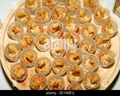 Assorted seafood appetizers served in small cups on a tray, ideal for catering events, cocktail parties, and elegant gourmet buffets. Stock Photo