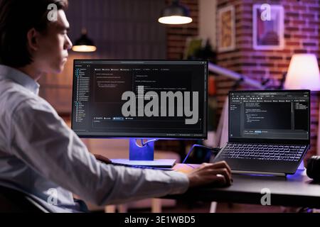 Male freelancer programming server encryption on firewall software, using security network interface to code system data for app development. Working with binary code text to script program. Stock Photo