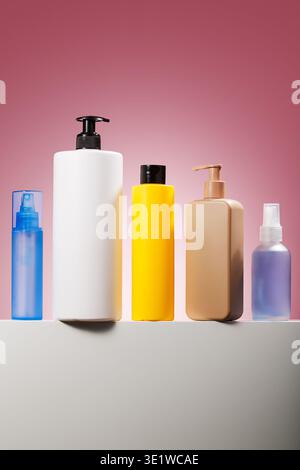 Assorted skincare bottles on pink studio background Stock Photo