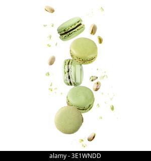 Flying green sweet pistachio macarons macaroons with crumbs and nuts isolated on white background Stock Photo