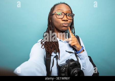 Black woman confidently taking a selfie on a sofa in her modern living ...