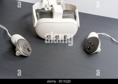 Modern virtual reality headset with two controllers placed on a black background. Concept of immersive technology, gaming and digital experience. Stock Photo