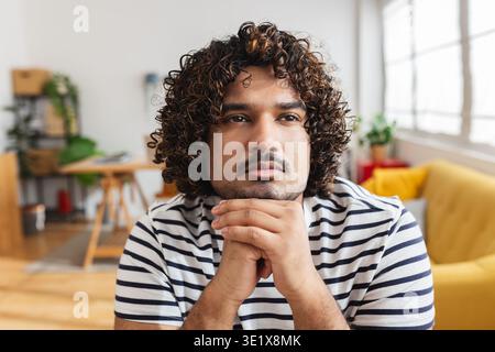 Young Indian man thinking at desk workplace Stock Photo