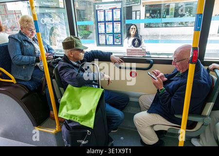 Malaga Spain,Andalusia Andalucia,city public bus transportation,onboard inside interior,passengers riders,elderly man senior citizen using smartphone Stock Photo