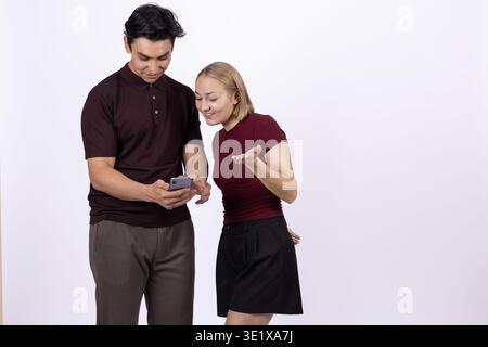 Young couple standing together and looking at smartphone screen Stock Photo