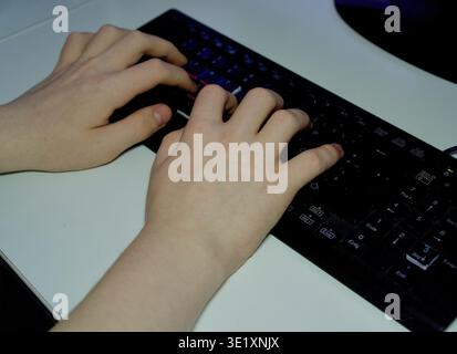 Close-up of a person's hands actively typing on a black computer keyboard. Functional workspace scene focusing on digital work, programming, or office productivity.-up of Hands Typing on a Black Computer Keyboard. High quality photo Stock Photo