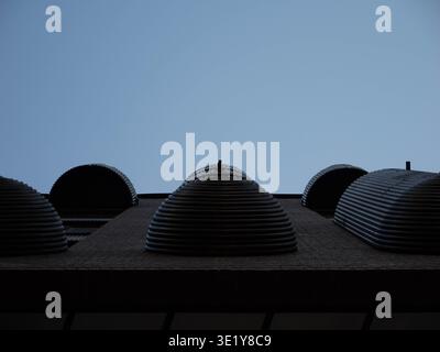 Ribbed ventilation domes on a rooftop in the Rottermani district, Tallinn, viewed from below against a clear spring sky Stock Photo