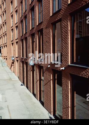 Red brick facade with industrial lamps along a narrow street in Rottermani district, Tallinn, spring Stock Photo
