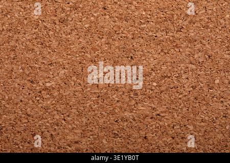 Close-up of natural cork board surface, showing organic texture and neutral brown color, ideal for backgrounds or design projects. Stock Photo