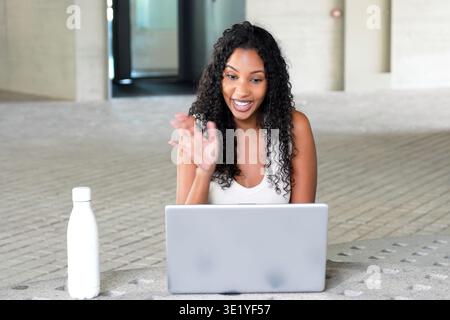 Woman using laptop with friendly expression. Happy woman interacts via video call at home Stock Photo