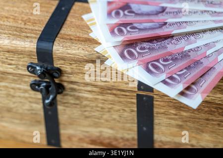A file of British pounds lying on a crate. A financial and business concept. English money. Close up Stock Photo