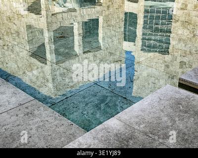 Abstract representation of several buildings with windows as reflected through the ripples of water in a reflecting pool. Stock Photo