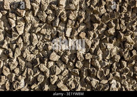 Rough stone wall texture background with natural rocks. Abstract pattern of irregular stones, earthy tones, construction material concept, seamless ru Stock Photo