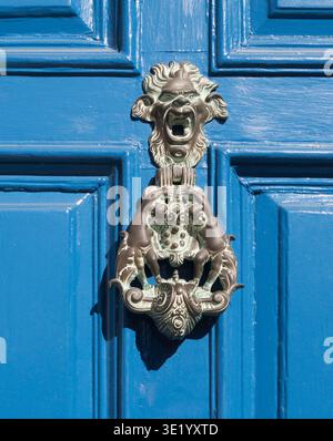 An ornate Lion's head door knocker with two figures seen in Palace Green, Durham, north east England, uk Stock Photo