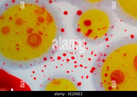 Vibrant yellow circles float amid red specks on a white background. Soft, textured surface holds playful, abstract forms. Glowing hues suggest energy Stock Photo