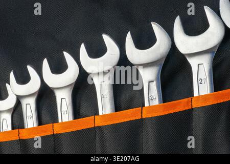 Close-up of open-end wrench set stored in a black tool roll organizer showing different sizes used for repair, maintenance and mechanical work Stock Photo