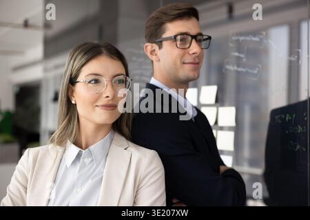 Hispanic professionals dressed in formal wear posing together in office Stock Photo
