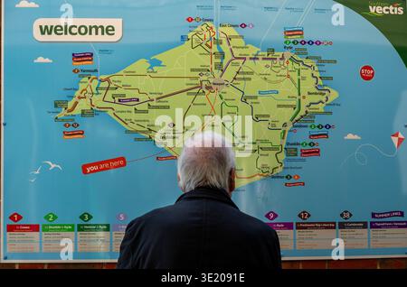 Senior man looking at a bus map of the isle of wight at the Southern Vectis bus station in Newport on the isle of wight, England, UK Stock Photo