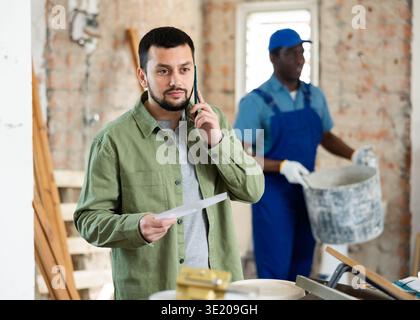 Architect talking on phone at construction site Stock Photo