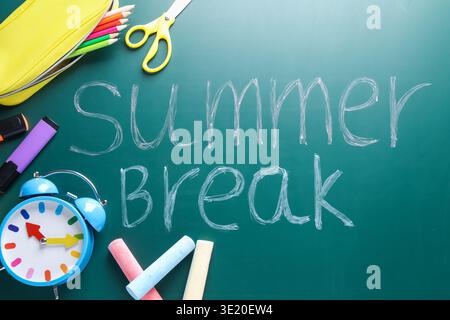 Words Summer Break, school supplies and alarm clock on chalkboard, flat lay Stock Photo