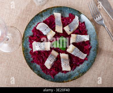 On pillow of beetroot salad - pieces of lightly salted herring are arranged in circle Stock Photo