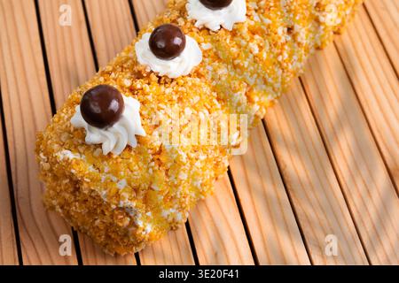 Delicious Swiss Roll Cake With Chocolate Spheres And Whipped Cream On A Wooden Table Stock Photo