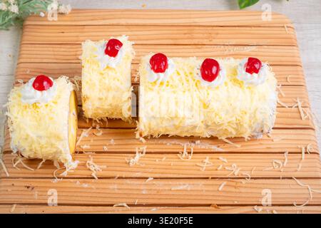Delicious Swiss Roll Cake With Grated Cheese Cream Filling And Cherries On Top Served On A Wooden Board Stock Photo