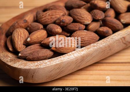 Close Up Of Rustic Wooden Scoop Filled With Fresh Almonds On A Wooden Surface Stock Photo