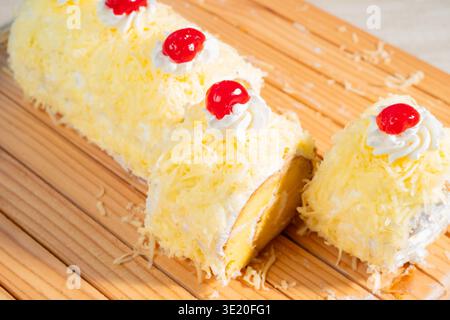 Delicious Yellow Sponge Cake Roll Topped With Cream Cheese And Cherries On A Wooden Board Stock Photo