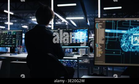Data center engineer working on artificial intelligence neural network software development. Server hub IT professional implementing machine learning technology in workplace, camera A Stock Photo