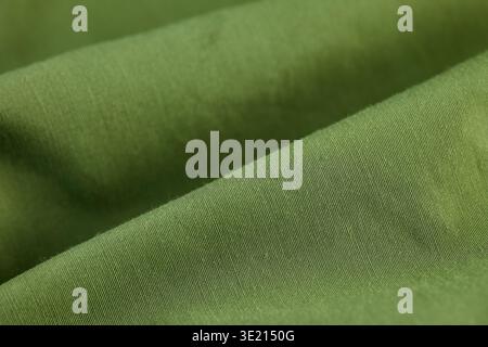 High-angle macro of olive green technical fabric showing diagonal weave and soft material folds Stock Photo